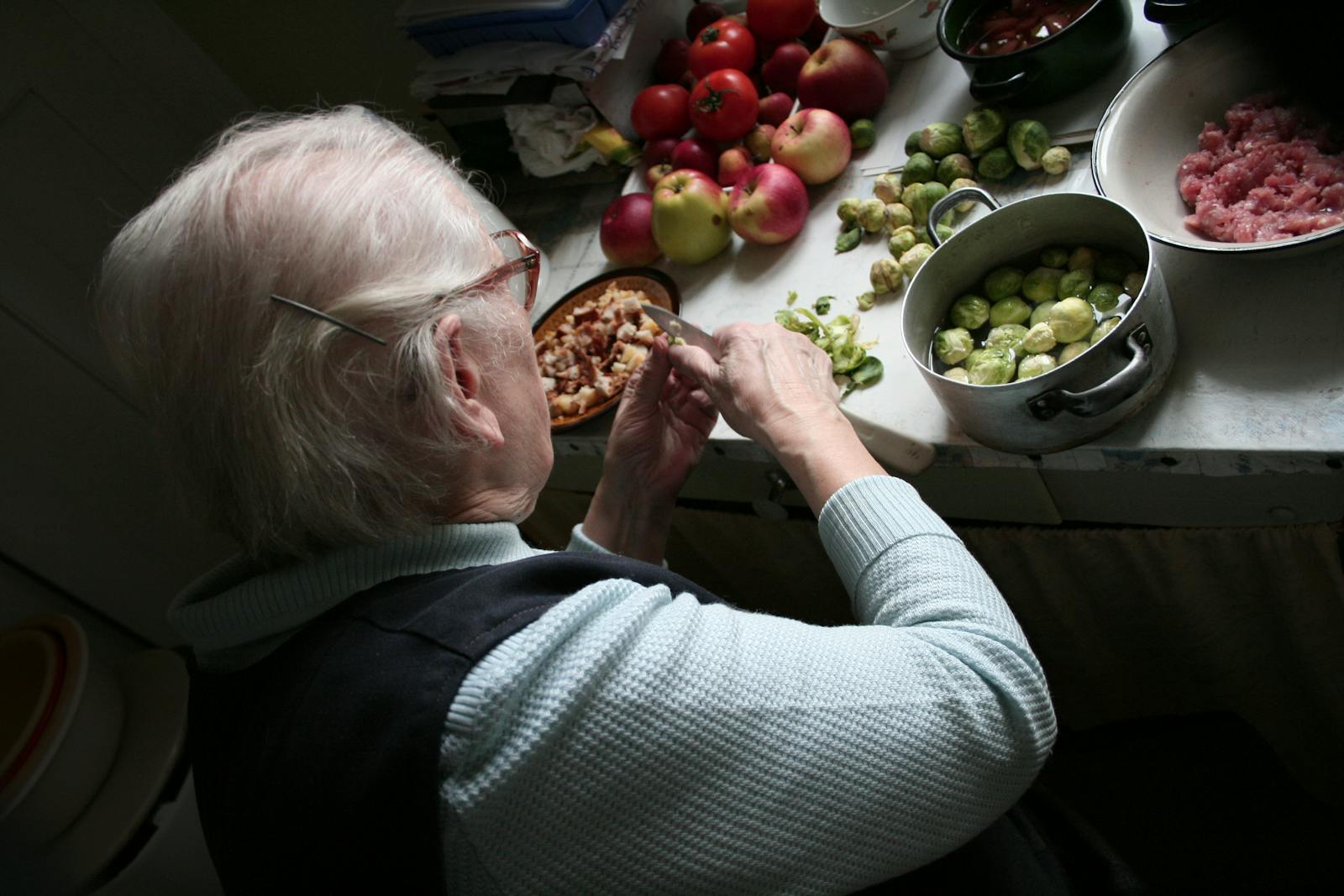 older woman cooking vegetables