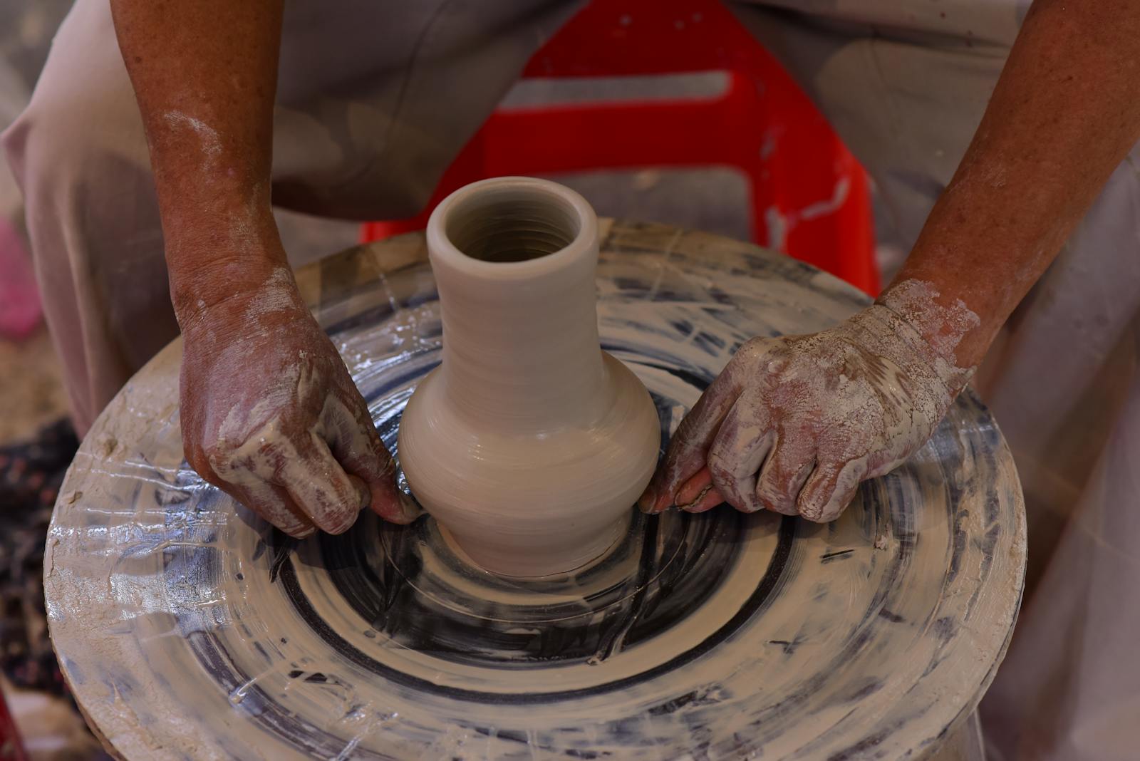older woman learning pottery