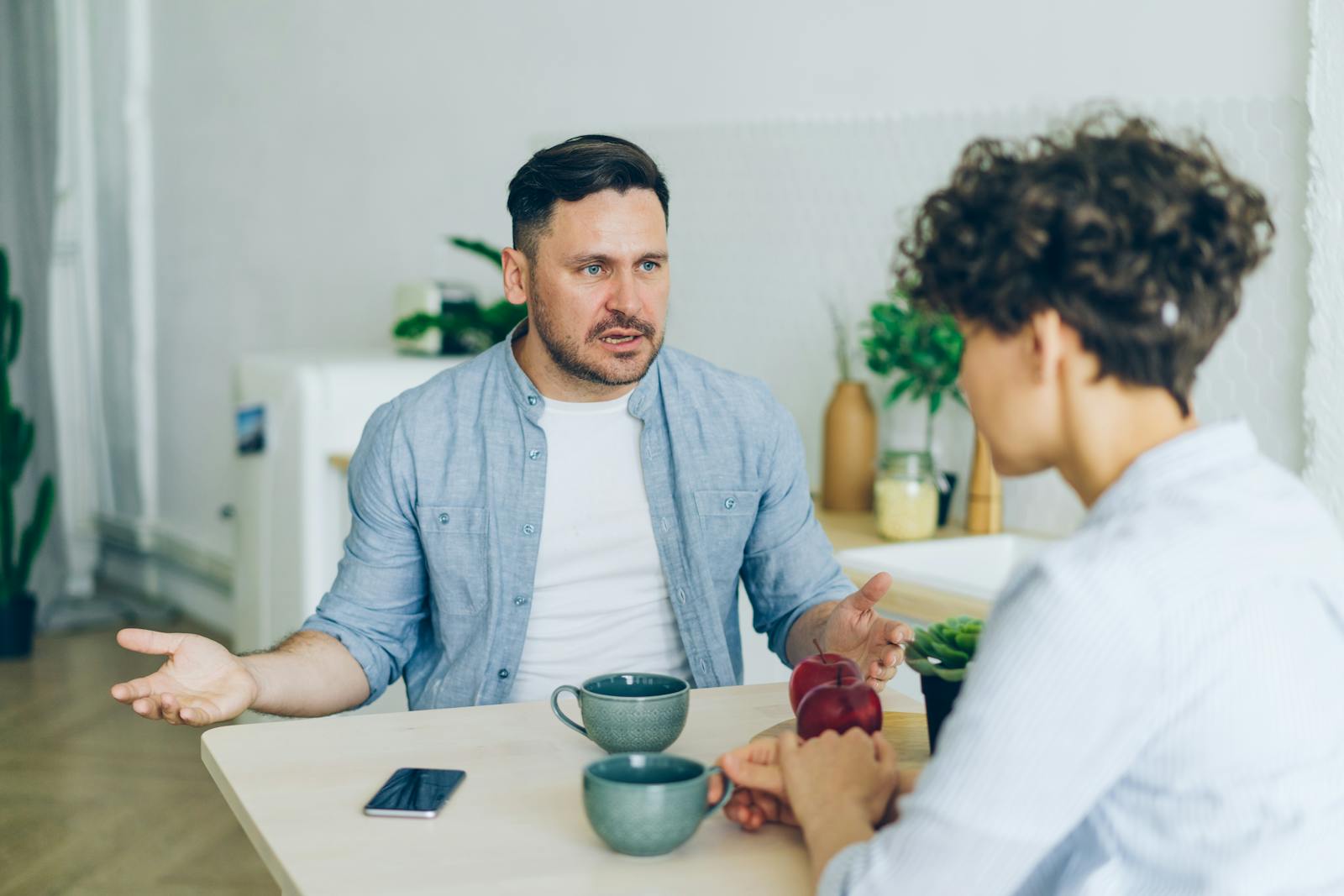 two people talking at kitchen table