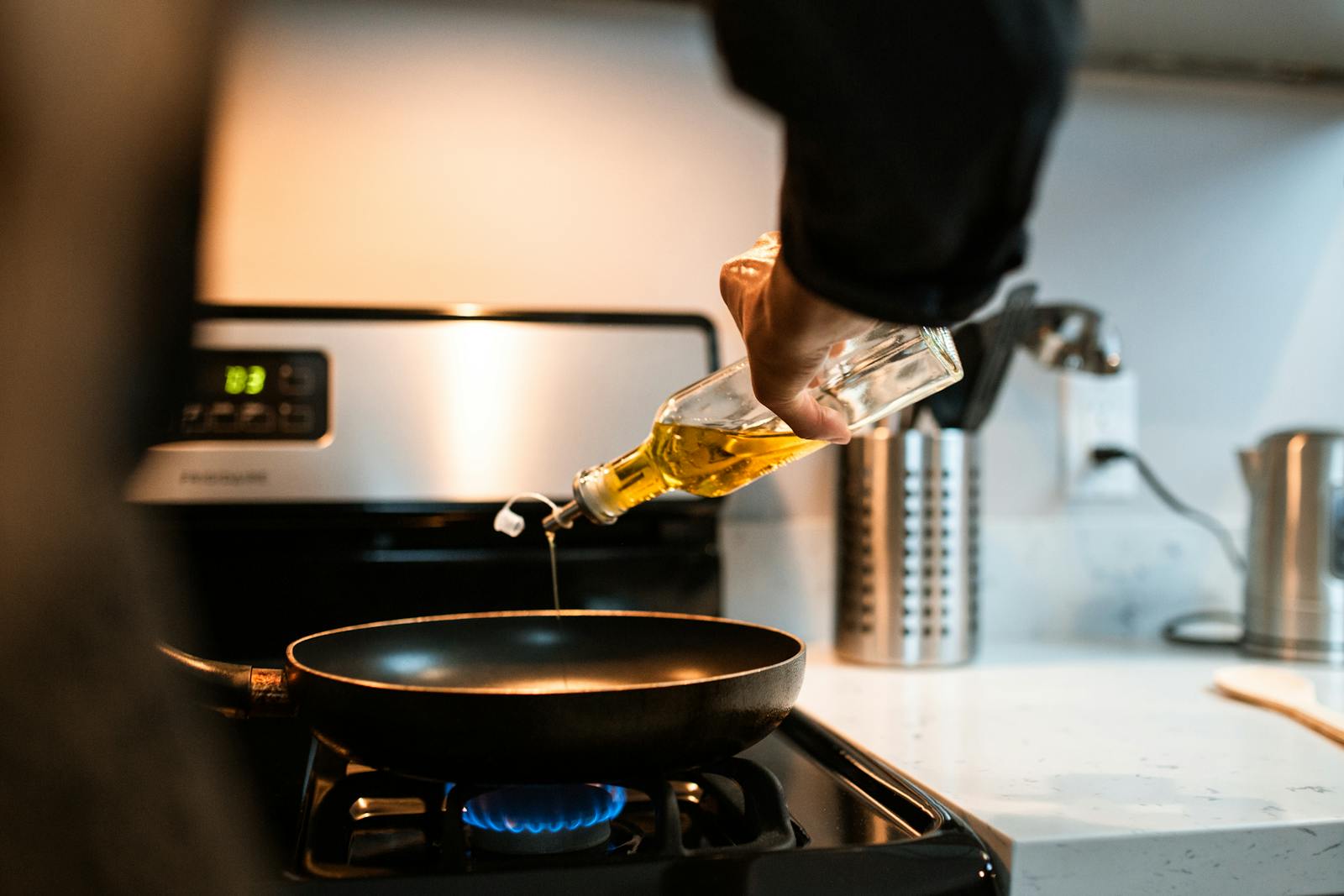 hand pouring olive oil