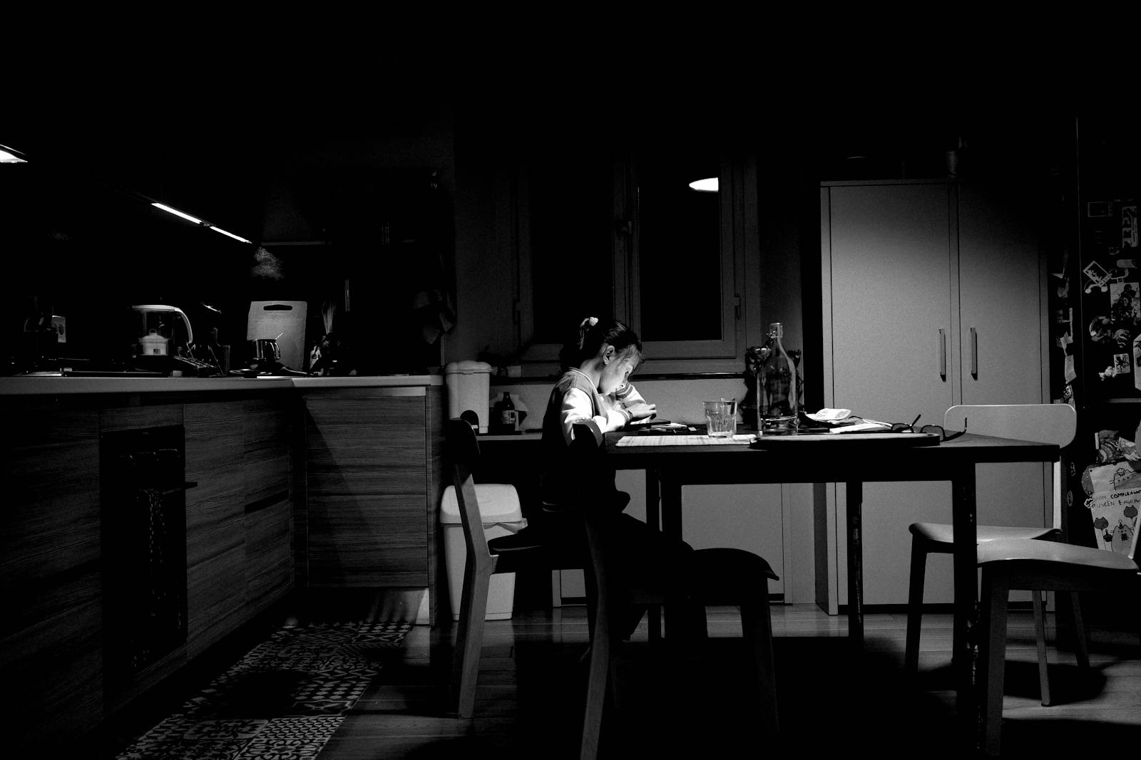 person sitting alone kitchen evening