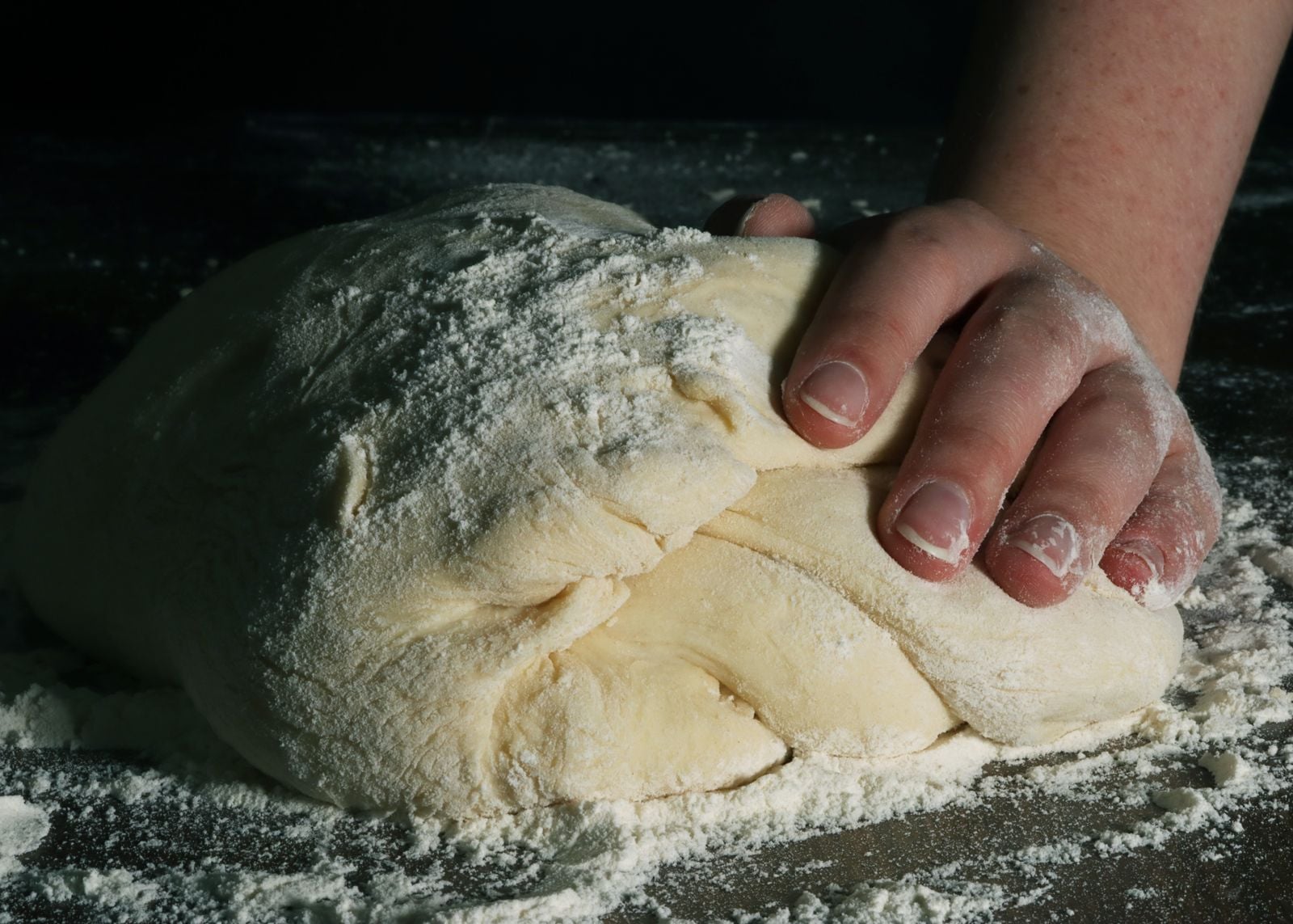 older hands kneading dough